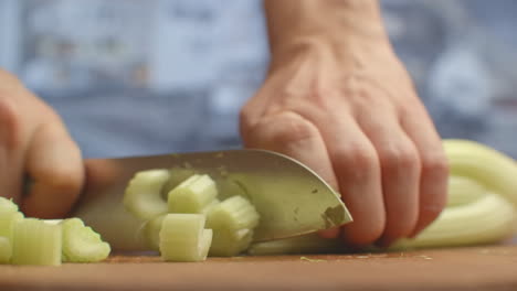 Close-up-of-cut-celery-on-a-board-in-the-kitchen-with-a-knife.